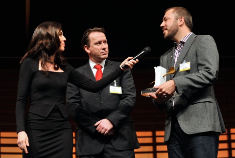 Preisgekrönt: Creative Director Tommy Schilling (r.) und Coop Marketingleiter Thomas Schwetje (m.) nehmen von Susanne Wille die Swiss Marketing Trophy 2012 entgegen.
